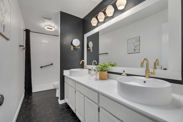 bathroom featuring tiled shower, tile patterned flooring, vanity, and toilet