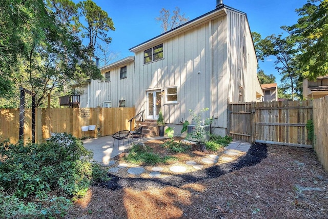 back of property with central AC unit and a patio area