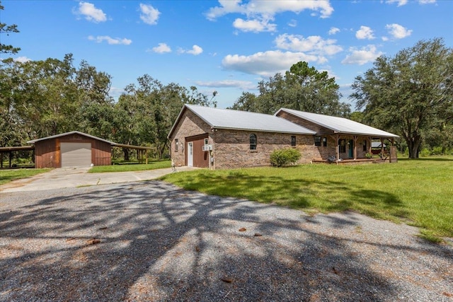 view of front of property with an outbuilding, a front yard, a carport, and a garage