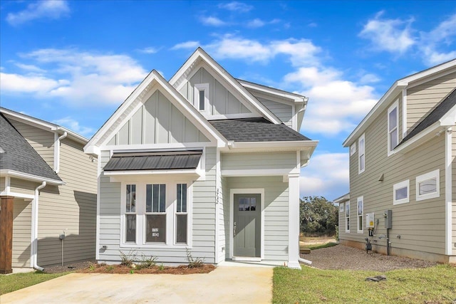 view of front of house with a standing seam roof, board and batten siding, roof with shingles, and metal roof