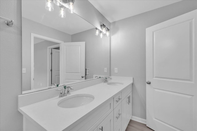 full bath featuring double vanity, baseboards, and a sink