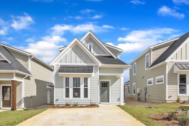 view of front facade featuring board and batten siding, metal roof, a standing seam roof, and roof with shingles