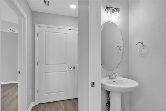 bathroom with a sink, visible vents, and wood finished floors