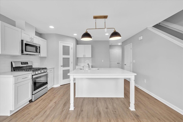 kitchen featuring a sink, stainless steel appliances, baseboards, and light countertops