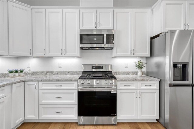 5756 Bascom Ln, Tallahassee, FL 32309 - kitchen with stainless steel appliances, white cabinets, and light stone counters