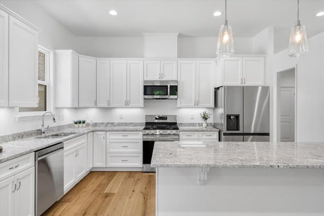 5756 Bascom Ln, Tallahassee, FL 32309 - kitchen with appliances with stainless steel finishes, a sink, white cabinets, light wood-style flooring, and recessed lighting