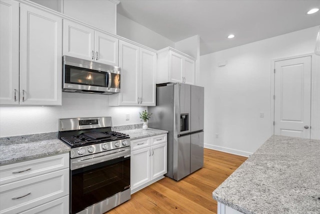 5756 Bascom Ln, Tallahassee, FL 32309 - kitchen featuring appliances with stainless steel finishes, white cabinets, light wood finished floors, light stone counters, and recessed lighting