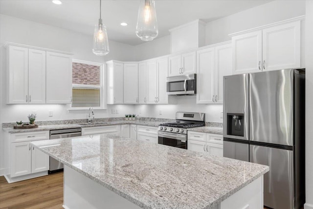 5756 Bascom Ln, Tallahassee, FL 32309 - kitchen featuring appliances with stainless steel finishes, a sink, white cabinets, a kitchen island, and pendant lighting