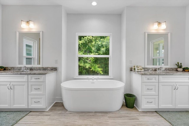 5756 Bascom Ln, Tallahassee, FL 32309 - full bathroom with two vanities, a freestanding tub, recessed lighting, and baseboards