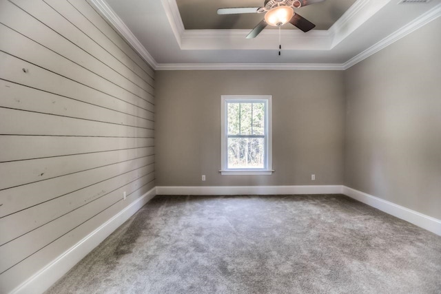 carpeted empty room with crown molding, ceiling fan, and a raised ceiling