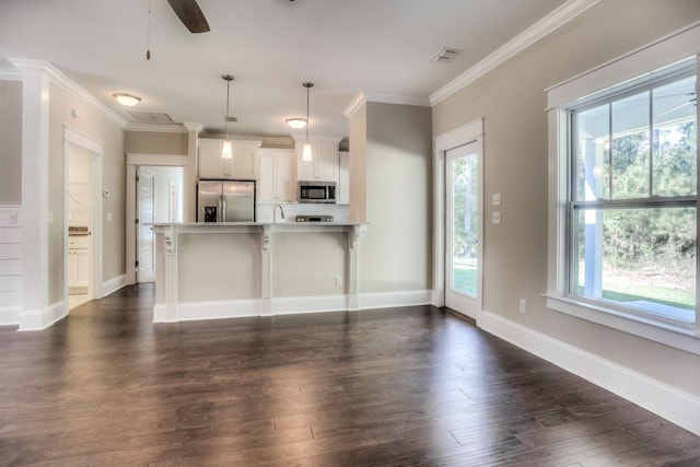 kitchen featuring hanging light fixtures, a kitchen breakfast bar, kitchen peninsula, stainless steel appliances, and white cabinets