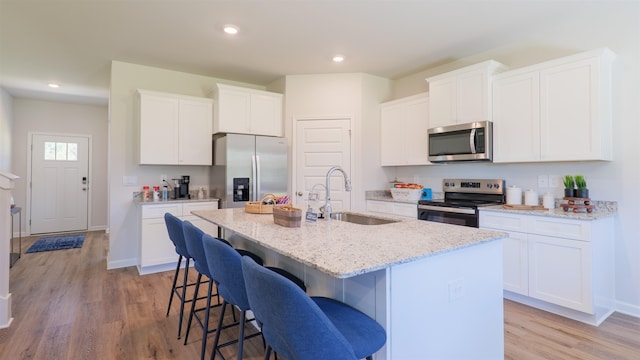 2986 Ervine St, Tallahassee, FL 32308 - kitchen featuring stainless steel appliances, a kitchen island with sink, a breakfast bar area, light wood finished floors, and recessed lighting