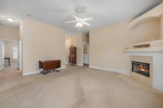 living room featuring ceiling fan, a fireplace, and light carpet