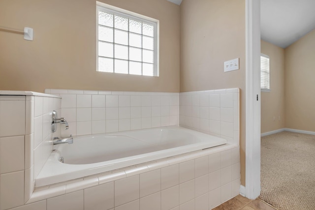 bathroom with a relaxing tiled tub