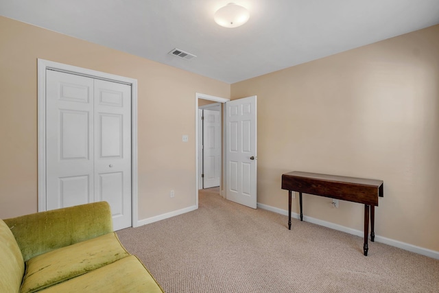 sitting room featuring light colored carpet