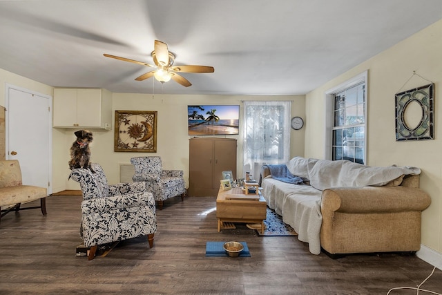 living room featuring dark wood-type flooring and ceiling fan