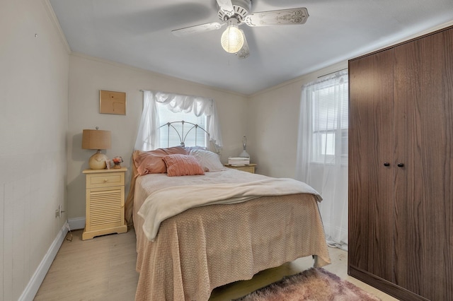 bedroom with ornamental molding, multiple windows, ceiling fan, and light hardwood / wood-style flooring