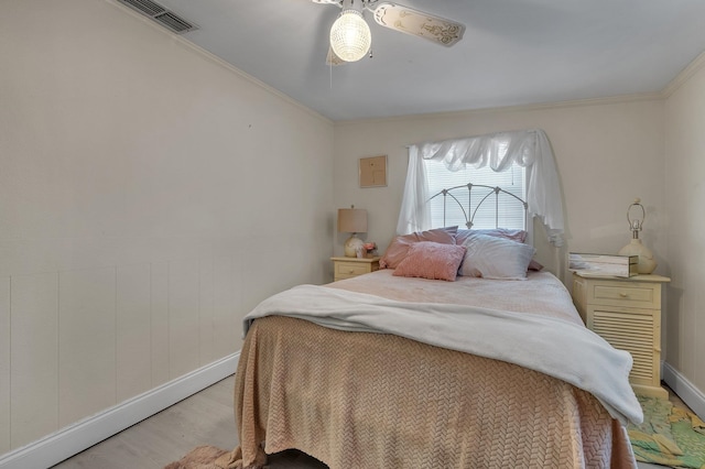 bedroom featuring ceiling fan, light wood-type flooring, and crown molding