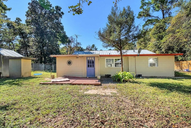 rear view of property featuring a yard and a deck