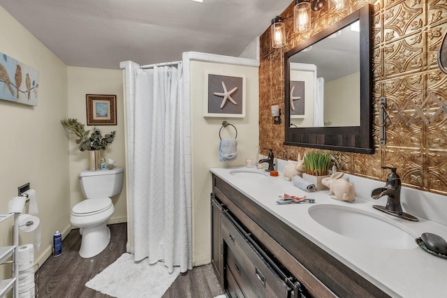 bathroom with toilet, vanity, hardwood / wood-style flooring, and curtained shower