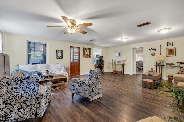 living room with dark hardwood / wood-style flooring and ceiling fan