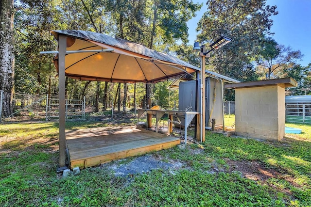 view of community featuring a wooden deck, a gazebo, and a storage shed