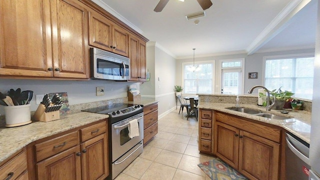 kitchen featuring appliances with stainless steel finishes, sink, hanging light fixtures, ornamental molding, and light stone counters