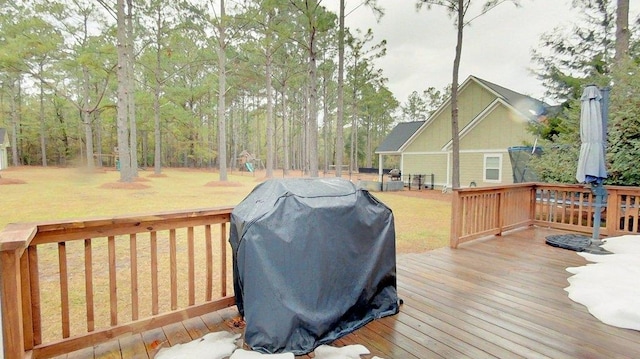 deck with a grill and a yard