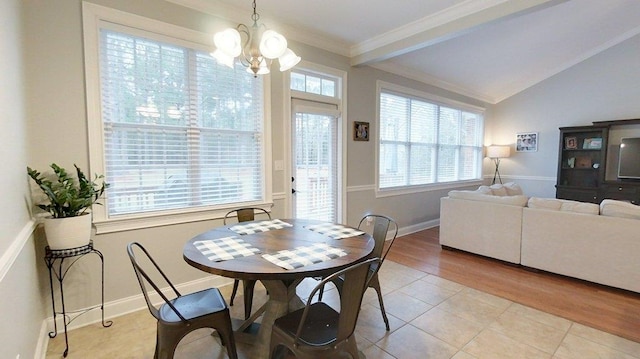 dining space featuring lofted ceiling, ornamental molding, an inviting chandelier, and light tile patterned flooring