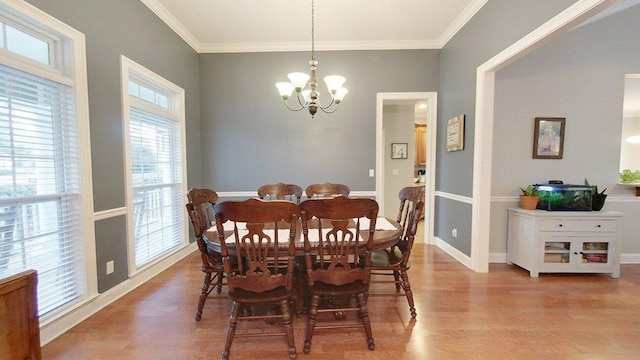 dining space featuring hardwood / wood-style flooring, ornamental molding, and a chandelier