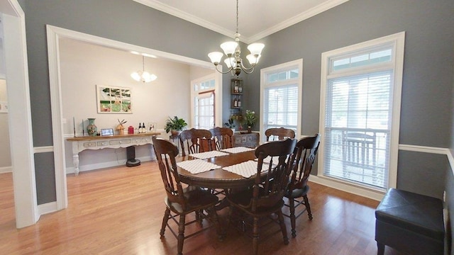 dining area with crown molding, wood-type flooring, and a chandelier