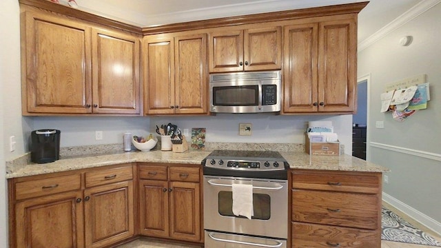 kitchen with ornamental molding, stainless steel appliances, and light stone countertops