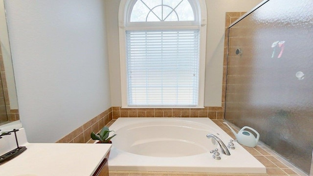 bathroom with vanity and tiled tub