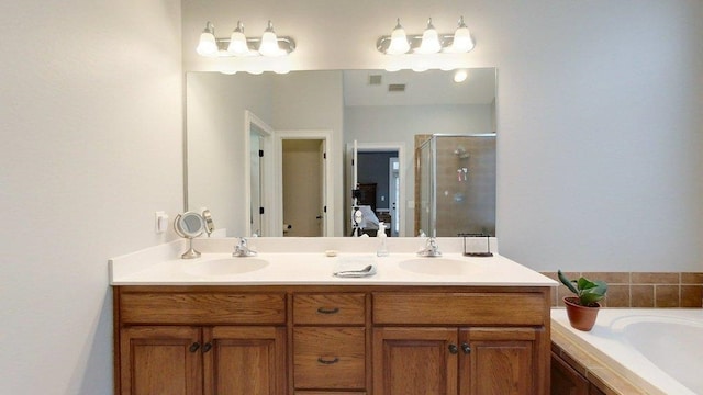 bathroom with vanity and shower with separate bathtub