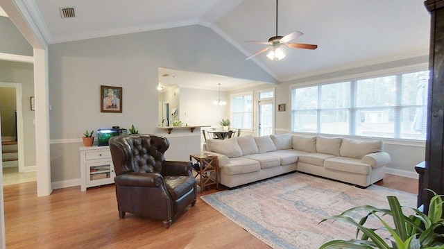 living room featuring ceiling fan with notable chandelier, light hardwood / wood-style flooring, a healthy amount of sunlight, and vaulted ceiling