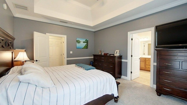 carpeted bedroom featuring ornamental molding, a tray ceiling, and connected bathroom