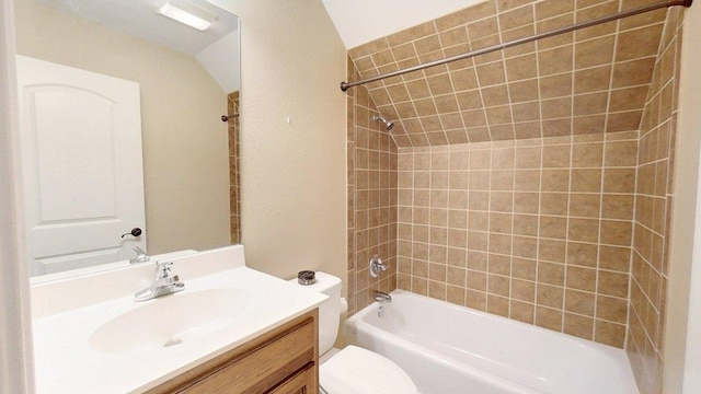 full bathroom featuring tiled shower / bath combo, vanity, and toilet