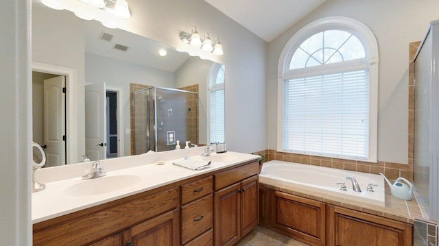 bathroom featuring a healthy amount of sunlight, plus walk in shower, vaulted ceiling, and vanity