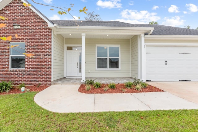 single story home featuring a garage, a front yard, and covered porch