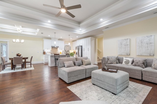 living room featuring hardwood / wood-style flooring, ceiling fan with notable chandelier, a skylight, and crown molding