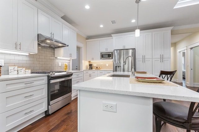 kitchen with white cabinets, dark hardwood / wood-style floors, a kitchen island with sink, and appliances with stainless steel finishes