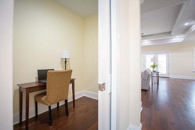 office featuring dark wood-type flooring, a raised ceiling, and ornamental molding