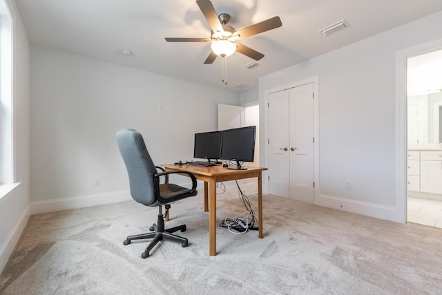 home office featuring light carpet and ceiling fan