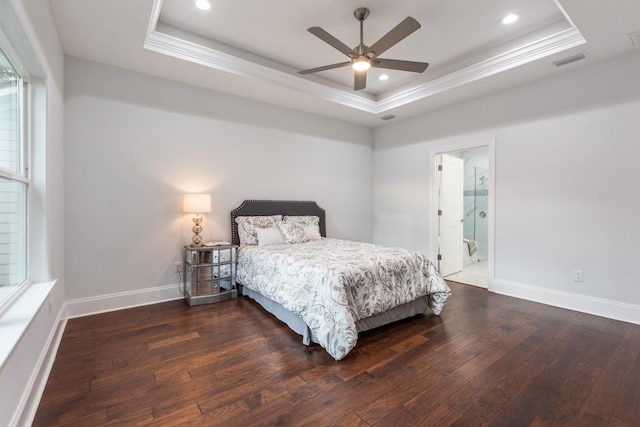 bedroom with ensuite bath, ceiling fan, a raised ceiling, crown molding, and dark wood-type flooring