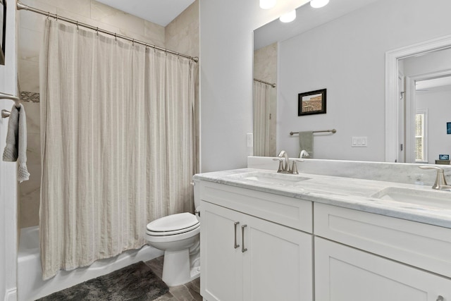 full bathroom with vanity, shower / tub combo, and toilet