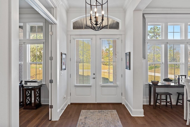 foyer entrance featuring a chandelier, dark hardwood / wood-style flooring, crown molding, and french doors