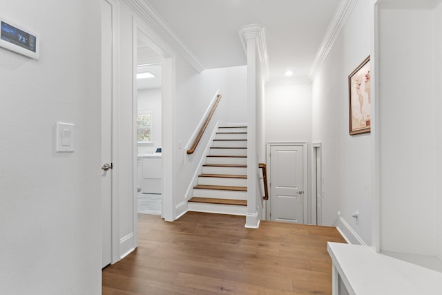 staircase with hardwood / wood-style floors, washer / dryer, and ornamental molding