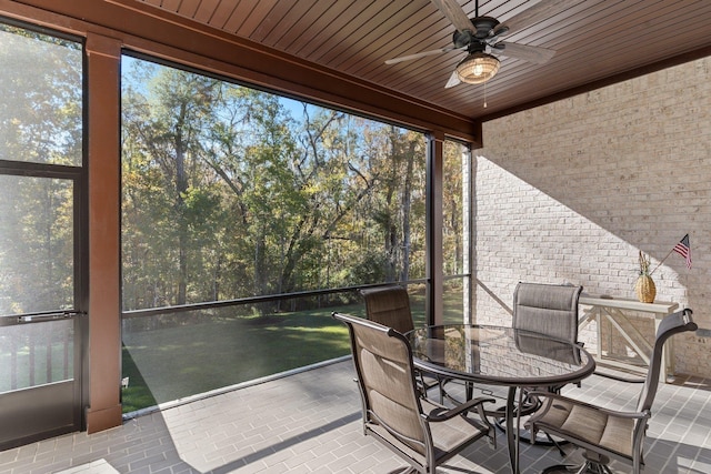 unfurnished sunroom with a wealth of natural light, ceiling fan, and wood ceiling