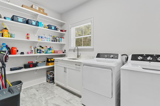 laundry area with washer and dryer, cabinets, and sink