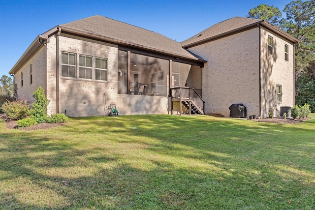 back of house featuring a lawn, a sunroom, and central AC unit